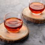 clear glass cup with black tea on brown wooden table