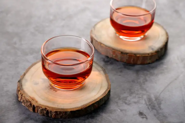 clear glass cup with black tea on brown wooden table